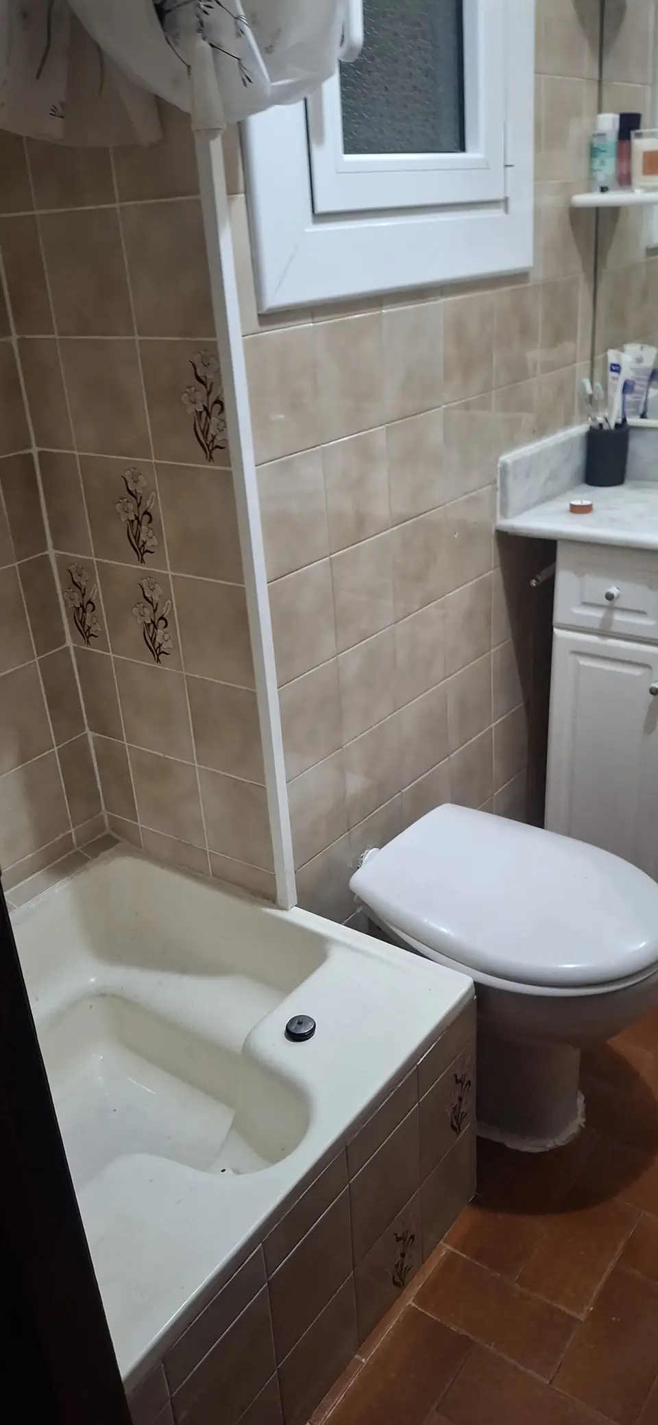 Baño con bañera, inodoro y paredes alicatadas